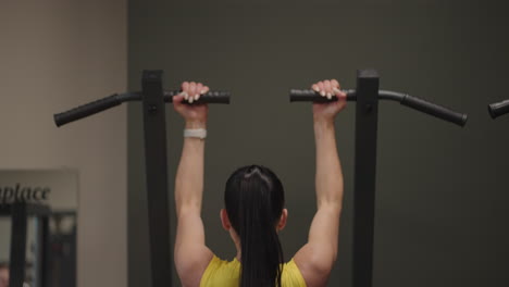 Hispanic-Woman-Does-Pull-Ups-On-Gravitron-For-Strengthening-The-Shoulder-Muscles-In-The-Gym.-A-woman-does-the-exercises-correctly-pulling-up-with-a-straight-back.-pull-ups-on-the-simulator
